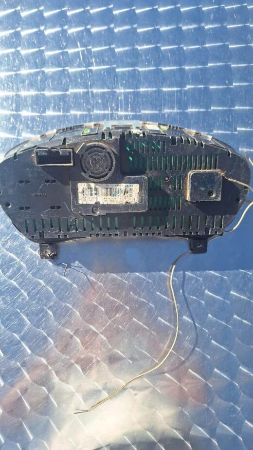 Dashboard instrument cluster showing speedometer and fuel gauge, top-down angled view.Dashboard instrument clu