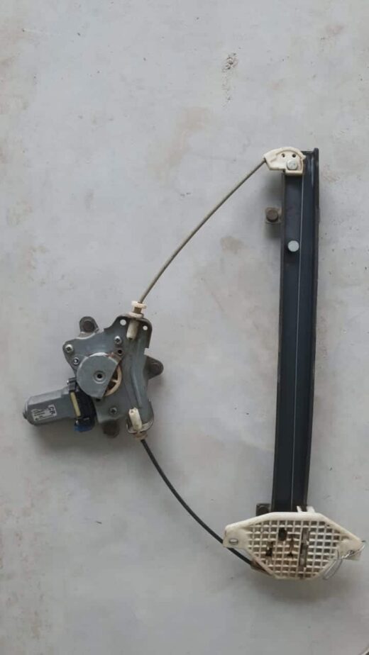 Close-up of a car window regulator assembly viewed from the side showing cables and mounting points.Close-up o