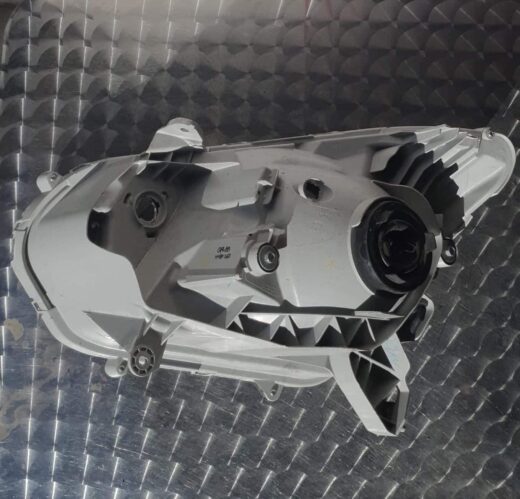 Right-side front headlight assembly for Isuzu KB, angled view showing lens and mounting points.Right-side fron