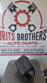 Top view of a black air filter housing angled slightly to show the intake and mounting points.Top view of a bl
