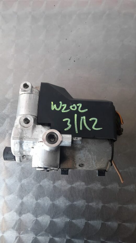 Used ABS pump for Mercedes W202 shown from top angle with visible motor and mounting points.Used ABS pump for