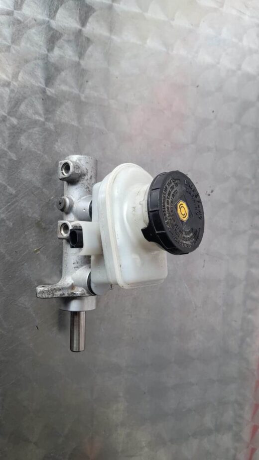 Front-side view of a brake master cylinder for Isuzu KB on a white background.Front-side view of a brake maste