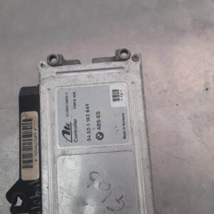 ABS control module for BMW E36, front view showing mounting bracket and electrical connector.ABS control modul