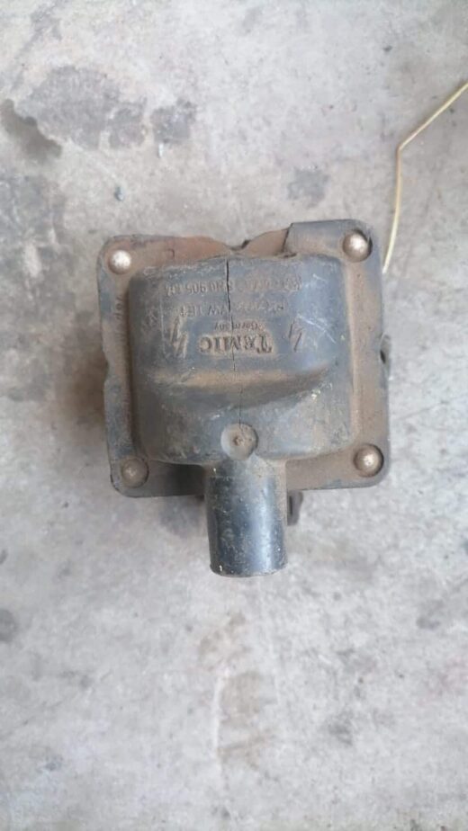 Used VW coil viewed from a slightly angled side showing mounting points and electrical connector.Used VW coil