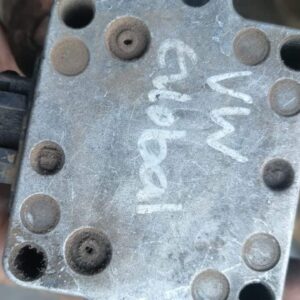 Front view of a used VW coil with visible wiring and mounting bracket on a white background.Front view of a us