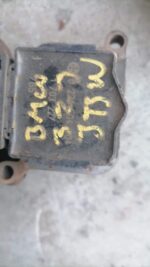 Front angle view of a used BMW E46 coil showing a black cylindrical component with wiring harness attached.Fro