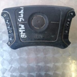 Front view of a BMW steering wheel airbag module displaying the central cover and mounting points.Front view o