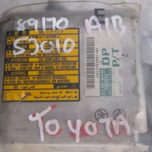 Front view of a rectangular airbag control unit with metal casing and attached wiring harness.Front view of a