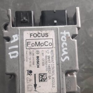 Top view of a compact black Ford Focus airbag control unit with attached wiring harness against a white backgr