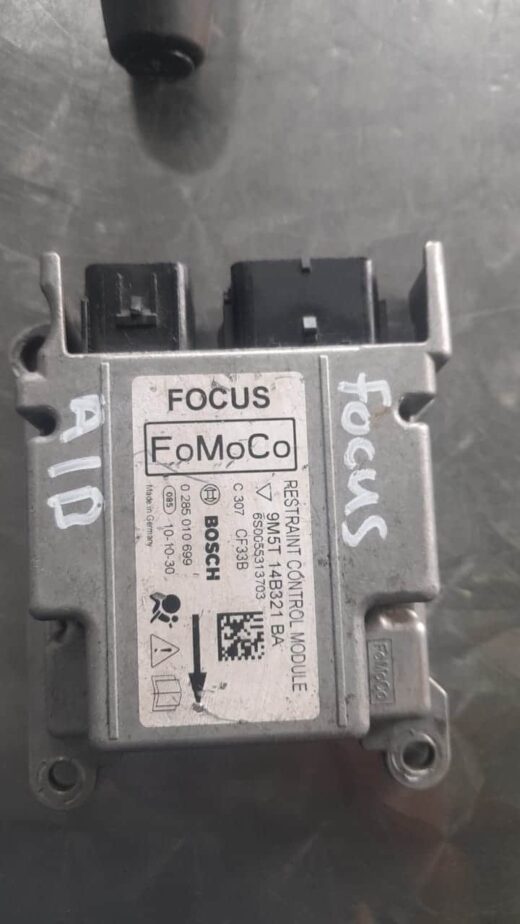 Ford Focus Airbag Control Unit 9M5T14B321 Top view of a compact black Ford Focus airbag control unit with attached wiring harness against a white backgr