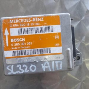 Front view of a Mercedes SL320 air bag control module with wiring and mounting bracket visible.Front view of a