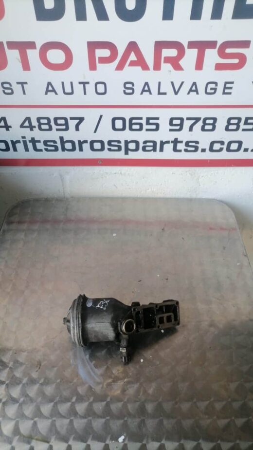 Bmw E36 318 Oil Filter Housing Front view of a clean BMW E36 318 oil filter housing showing mounting points and oil passage openings.Front vi
