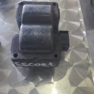 Close-up of a 1.6 engine coil pack positioned upright, showing multiple ignition coil terminals.Close-up of a