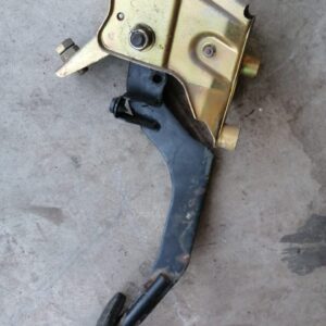 Close-up of a car pedal assembly viewed from the side, featuring metal and rubber components.Close-up of a car