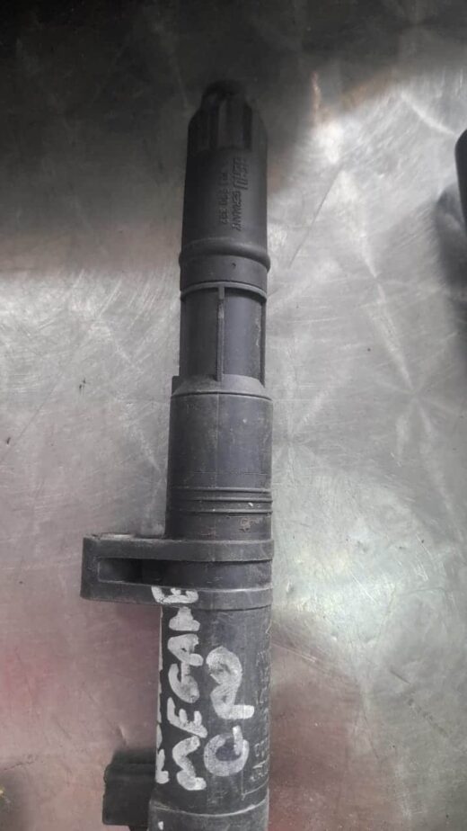 Renault Megane Ignition Coil Used ignition coil viewed from the side showing electrical connectors and mounting points.Used ignition coil v