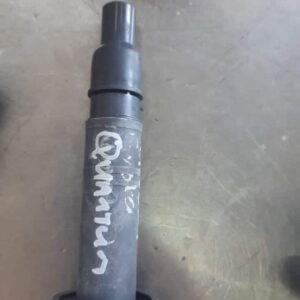 Angled view of a used ignition coil designed for Toyota Quantum, showing connectors and coil housing.Angled vi