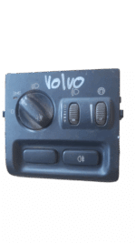 Front-facing view of a Volvo car headlight switch with illuminated orange indicators and black housing.Front-f
