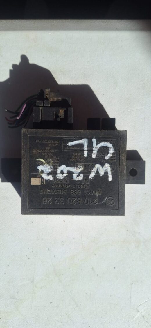 Top-down view of a Mercedes W210 central locking control unit with wiring and connectors visible.Top-down view