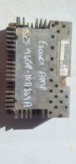Front angled view of a used car amplifier with metal casing and visible wiring terminals.Front angled view of