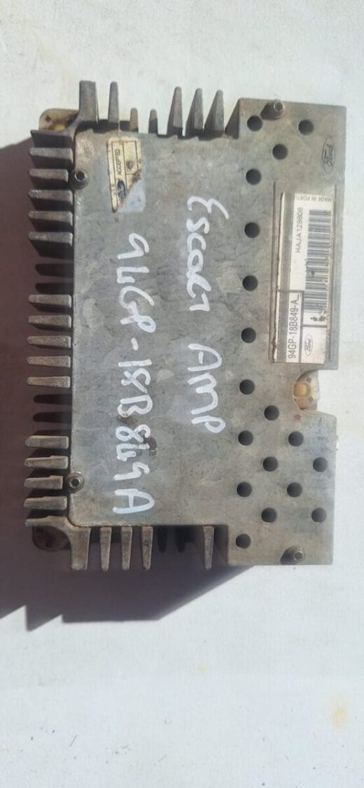 Front angled view of a used car amplifier with metal casing and visible wiring terminals.Front angled view of