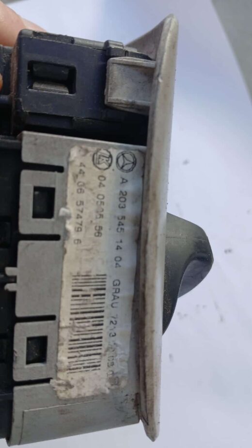 Used Mercedes W203 headlight switch viewed from front-left angle, showing control knob and connectors.Used Mer