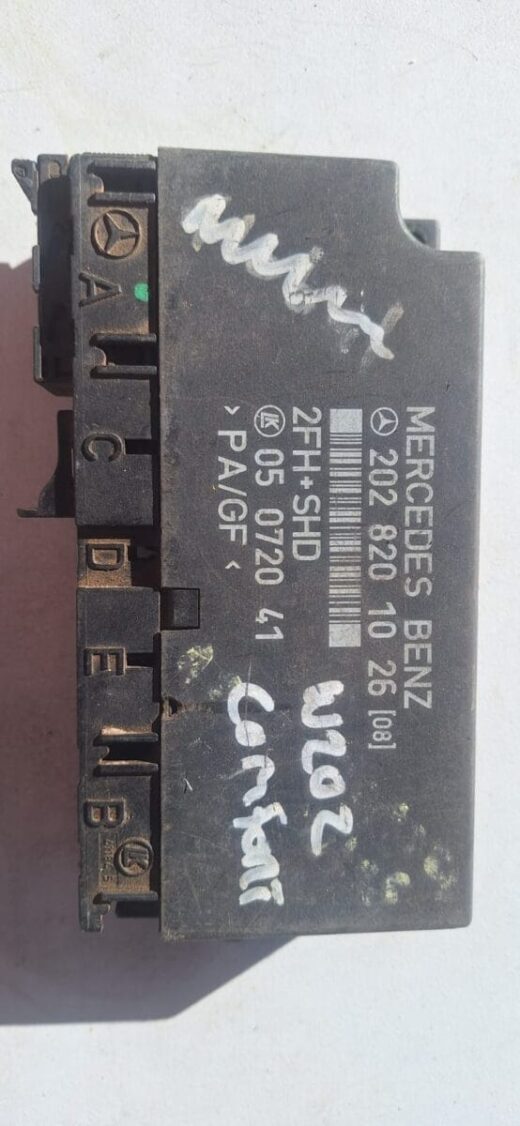 Front angle view of a rectangular automotive control module with wiring harness and connectors.Front angle vie