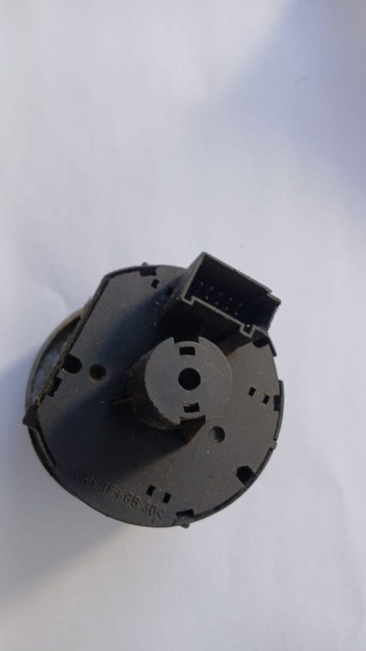 Close-up front view of a used VW Polo headlight switch showing its control knobs and mounting points.Close-up