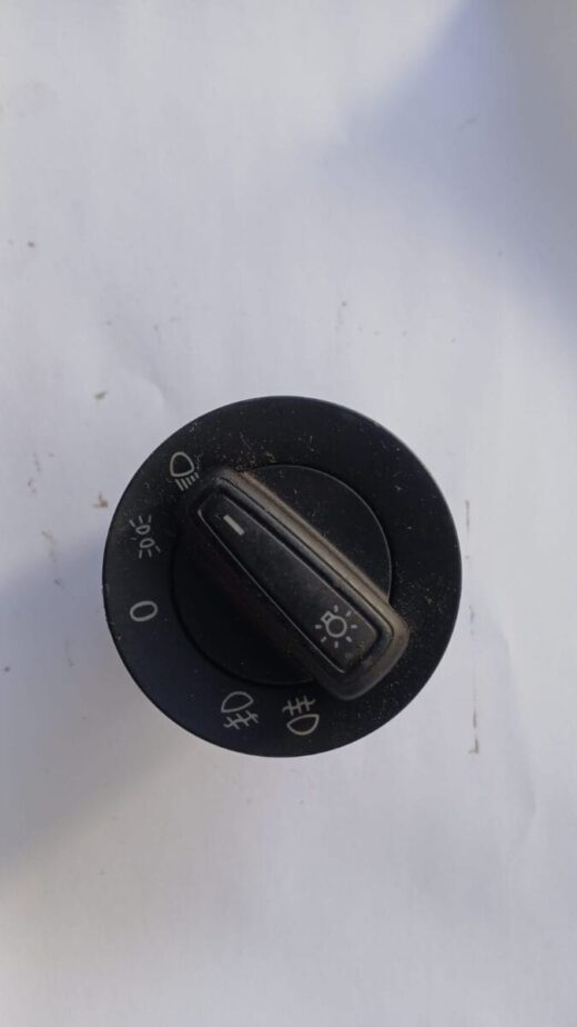 Close-up of a VW Polo headlight switch showing the control knob and mounting base from the front angle.Close-u