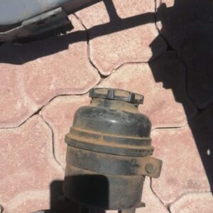 Used steering fluid reservoir for BMW E36 shown from a slight top angle against a white background.Used steeri