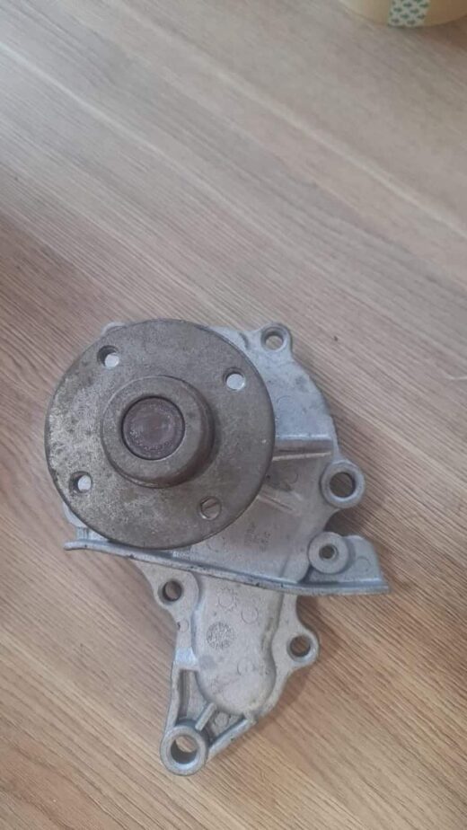 Water Pump New Front angled view of a new automotive water pump showing mounting points and pulley flange.Front angled view o