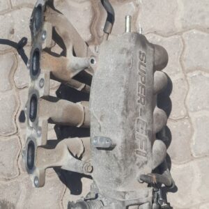 Front angled view of a Kia Shuma 2 1.6 intake manifold displayed against a plain background.Front angled view