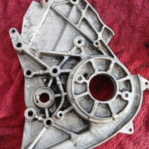 Close-up of a grey automotive timing belt cover viewed from the front, showing mounting points clearly.Close-u