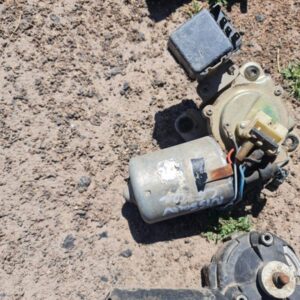 Used Datsun wiper motor shown from side angle highlighting electrical connectors and mounting points.Used Dats