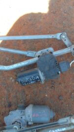 Used wiper motor for Mazda 3, shown from top angle with attached wiring and mounting points visible.Used wiper