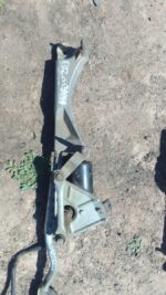 Front angle view of a used Mercedes W203 windshield wiper motor with attached wiring and mounting points.Front