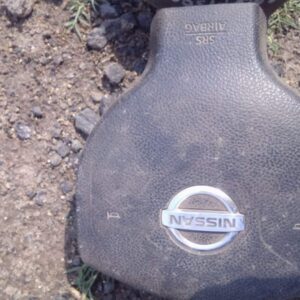 Front view of a used Nissan Tiida steering wheel airbag module with attached wiring and Horn button.Front view