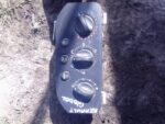Front view of used Renault dashboard climate control panel showing buttons and display screen.Front view of us