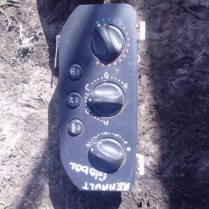 Front view of used Renault dashboard climate control panel showing buttons and display screen.Front view of us