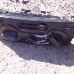 Front view of a used Daewoo Lanos climate control panel with buttons and dials on a black dashboard.Front view