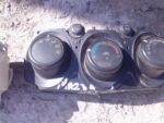 Front view of used Mazda 2 climate control panel featuring knobs and buttons for temperature and airflow setti