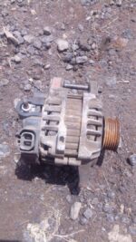 Front angled view of a used car alternator with mounting points and pulley visible.Front angled view of a used