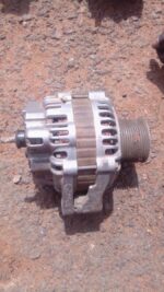 Used car alternator shown from front angle, displaying housing and pulley, clean and intact.Used car alternato