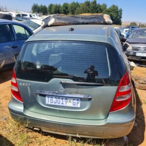 Front and side view of a stripped silver hatchback car with no doors or windows, showing internal frame and en