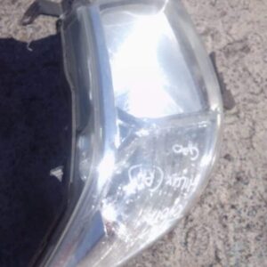 Right front vehicle headlight assembly angled to show lens and mounting points, used condition.Right front veh