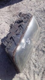 Left front headlight for BMW E46, angled slightly to show front and side, used condition.Left front headlight