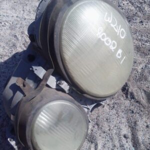 Front-facing left headlight assembly for Mercedes Benz W210, used condition, clean lens and wiring visible.Fro
