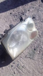 Left headlight for Nissan Hardbody, shown front angle, used condition visible.Left headlight for Nissan Hardbo