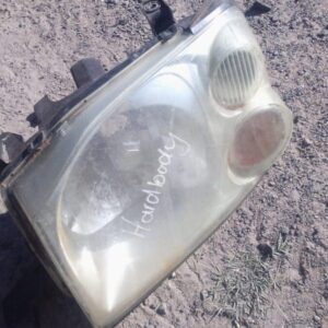 Left headlight for Nissan Hardbody, shown front angle, used condition visible.Left headlight for Nissan Hardbo