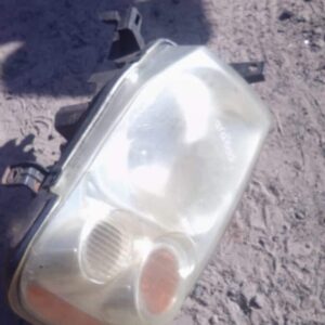 Right-side NP300 truck headlight assembly shown front-facing, used condition with visible wiring and mounting