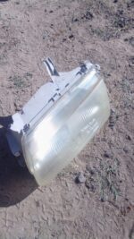 Right side used headlight for 2002 Mazda Etude shown from front angle on white background.Right side used head